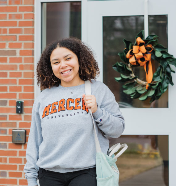 Student in front of Stembridge Center for Student Success